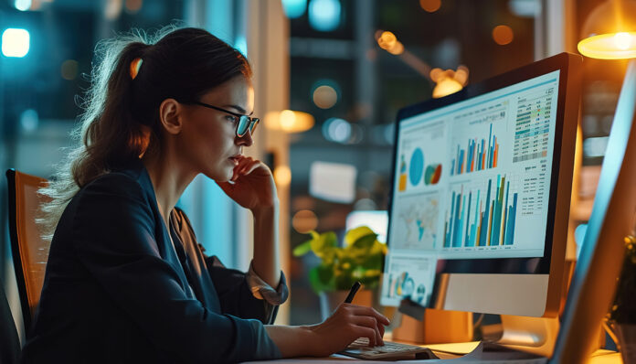 kobieta analizująca wykresy finansowe, symbol ekonomii behawioralnej